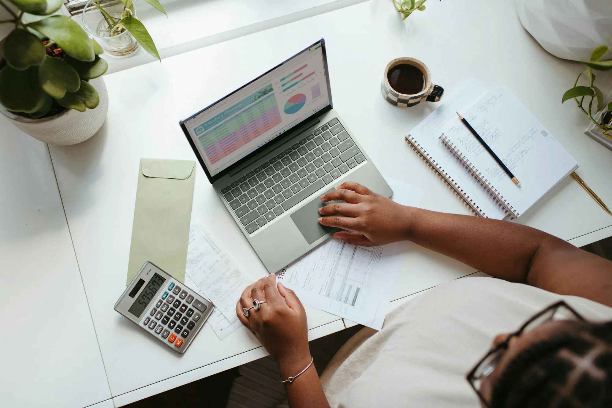 Un bureau avec un ordinateur, une calculatrice et des factures