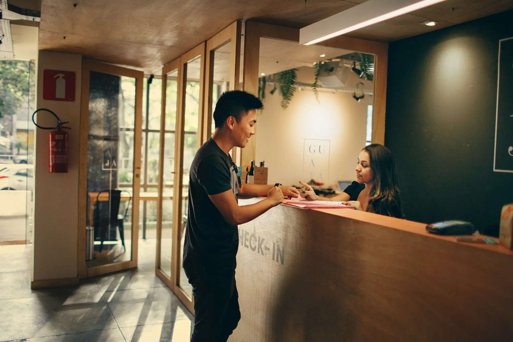 A guest at a hotel check-in desk talking with the receptionist